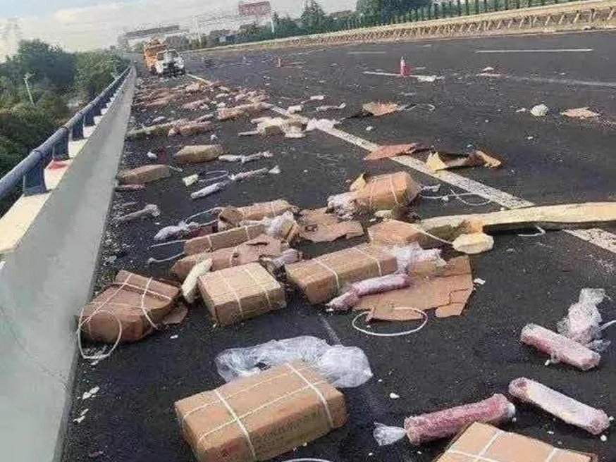 運輸凍豬肉的車輛發生事故,導致部分凍豬肉散落到高架橋下農村道路上。(網圖)