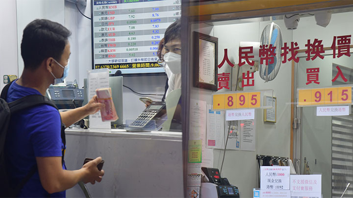 每百港元今日一度「穿九」,吸引市民到找換店換錢。