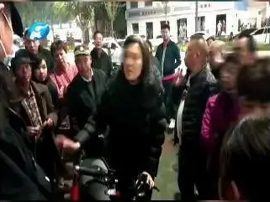 企圖帶走小孩的可疑女子,被群眾圍着。