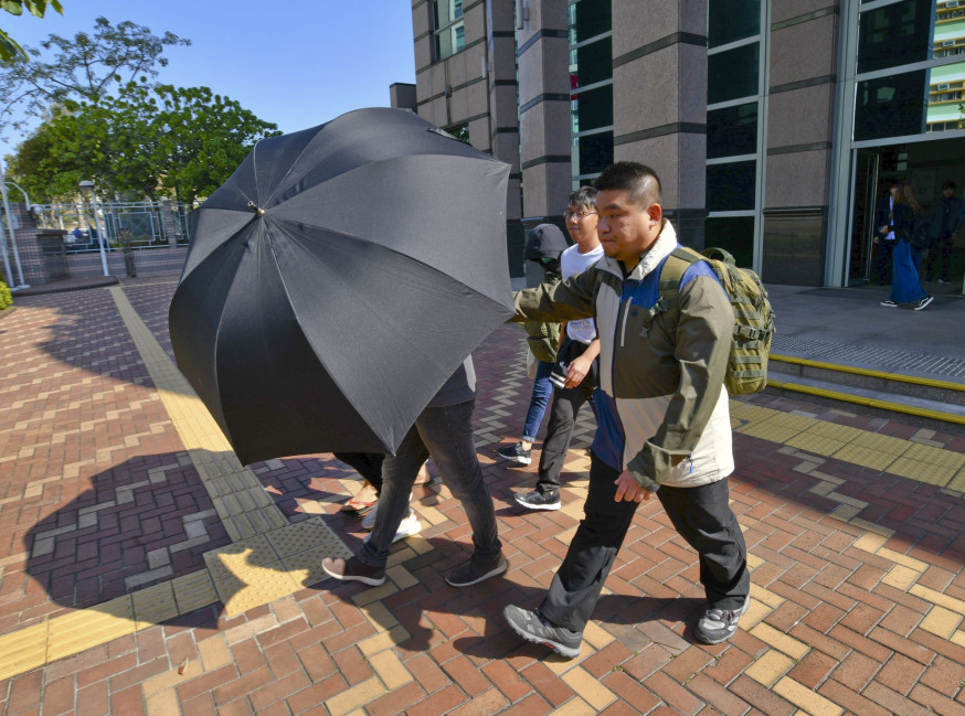 在天平邨被捕及遭起訴的教師連同其他被告今日提堂,在旁人掩護下離開。